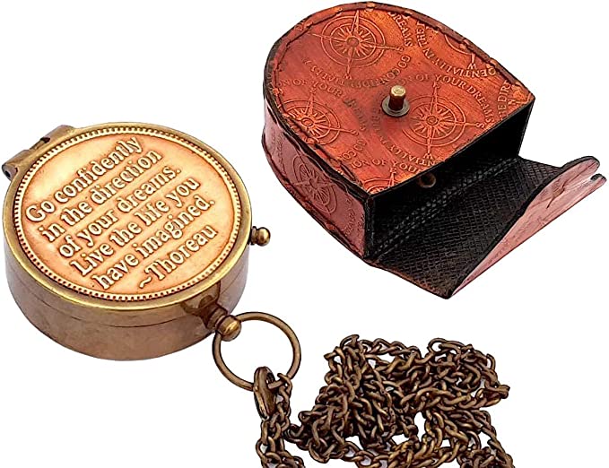 Thoreau's "Go Confidently" brass compass held in hand, showcasing its compact and portable design.