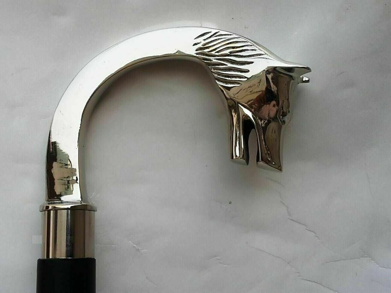 Close-up of the brass wolf head handle on a Victorian-style wooden walking stick with a sleek nickel silver finish.