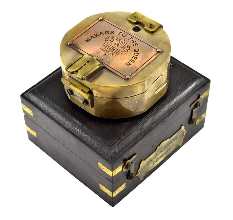 Close-up view of brass survey compass with antique finish and wooden case, showcasing detailed craftsmanship.