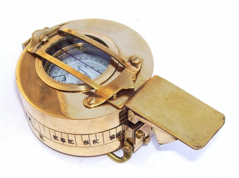 Person holding a Maritime Polished Brass Nautical British Prismatic Military Pocket Compass, showcasing its compact size and functionality.