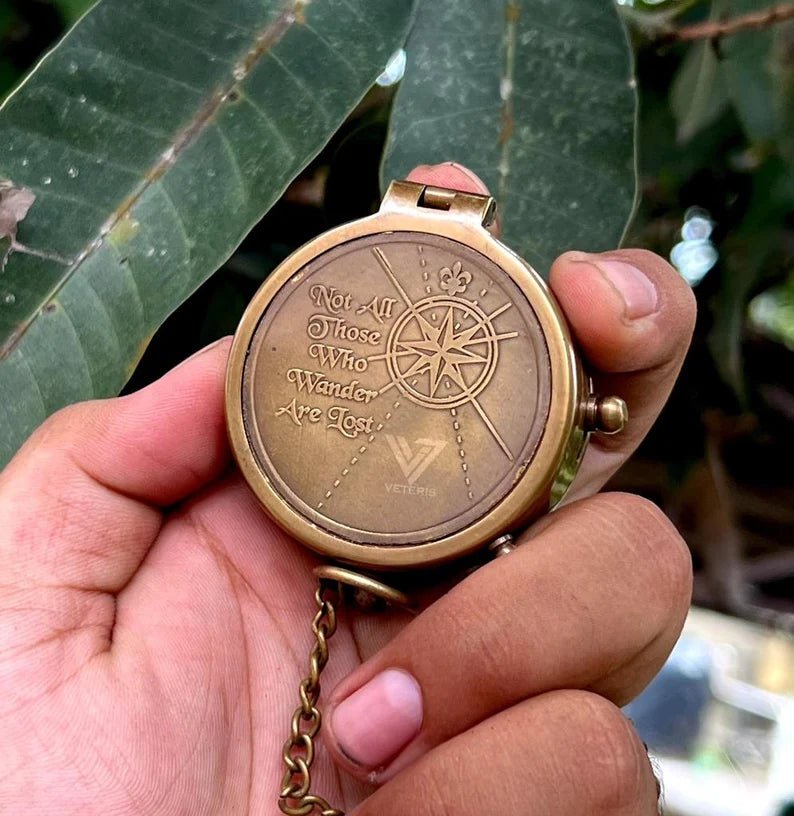 Close-up of solid brass engraved compass in antique finish with vintage design and personalized engraving.