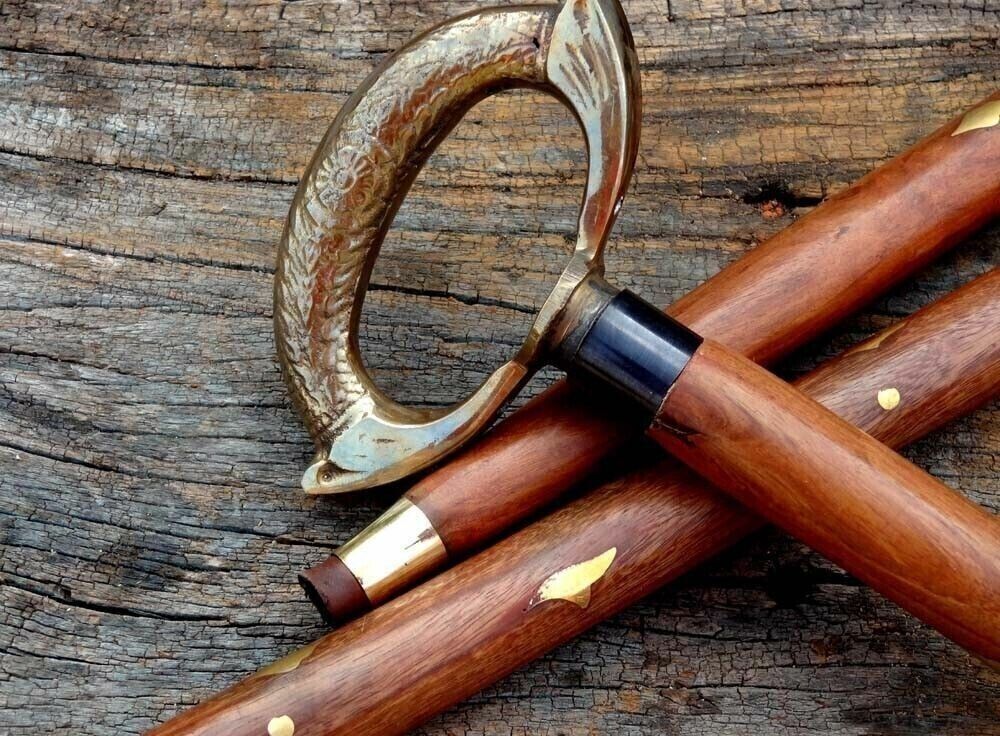 Solid brass handle on a wooden walking stick cane with an antique nautical design, perfect for collectors.