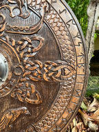 Person holding the Viking Round Dragon Shield, illustrating its ergonomic design and functionality.